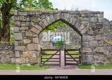 Torlundy, Schottland - Juni 11, 2012: Naturstein Tor mit dreieckiger Bogen in die Domäne von Inverlochy Castle in der Nähe von Fort William. Grünes Gras und Baum Stockfoto