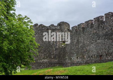 Torlundy, Schottland - Juni 11, 2012: Comyn Eckturm in grau-braun Naturstein Verteidigungsmauer mit Stadtmauer von Inverlochy Castle. Stellen sie unter dem grünen Stockfoto