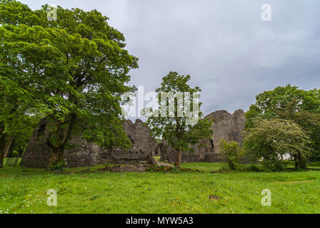 Torlundy, Schottland - Juni 11, 2012: die Ruinen von Naturstein Stadtmauer von Inverlochy Castle in der Nähe von Fort William. Außenansicht mit Bäumen. Grünes Gras und l Stockfoto