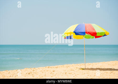 Einen bunten Regenschirm ist geöffnet an einem tropischen Strand an einem sonnigen Tag. Stockfoto