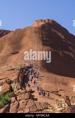 Zu Fuß bis Uluru oder Ayers Rock im Outback von Australien. Die Praxis ist unpopulär mit traditionellen Eigentümer des Landes und wird im Jahr 2019 verboten. Stockfoto