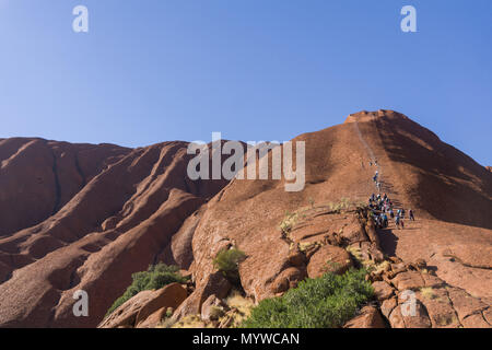 Zu Fuß bis Uluru oder Ayers Rock im Outback von Australien. Die Praxis ist unpopulär mit traditionellen Eigentümer des Landes und wird im Jahr 2019 verboten. Stockfoto