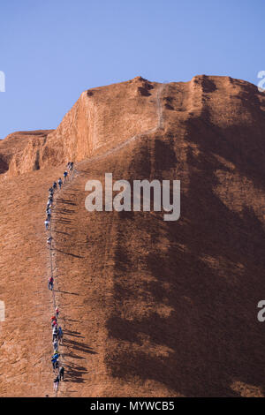 Zu Fuß bis Uluru oder Ayers Rock im Outback von Australien. Die Praxis ist unpopulär mit traditionellen Eigentümer des Landes und wird im Jahr 2019 verboten. Stockfoto