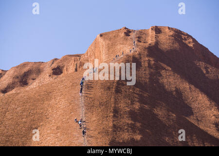 Zu Fuß bis Uluru oder Ayers Rock im Outback von Australien. Die Praxis ist unpopulär mit traditionellen Eigentümer des Landes und wird im Jahr 2019 verboten. Stockfoto