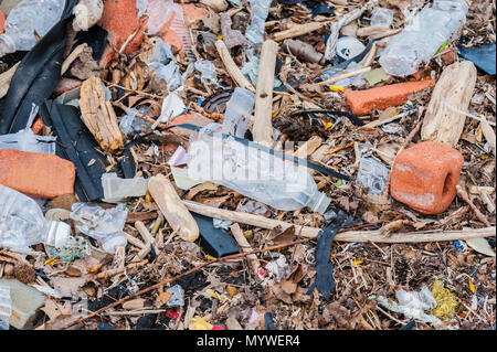 Zufällige Plastik, Abfälle, Müll, Schutt und Steinen auf dem Boden verstreut. Stockfoto