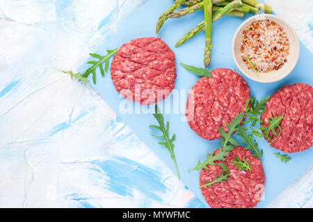 Rohe Koteletts für Grill. Fleisch für das Kochen Mittagessen und Gewürze und Spargel. Hintergrund für Text. Flach Stockfoto