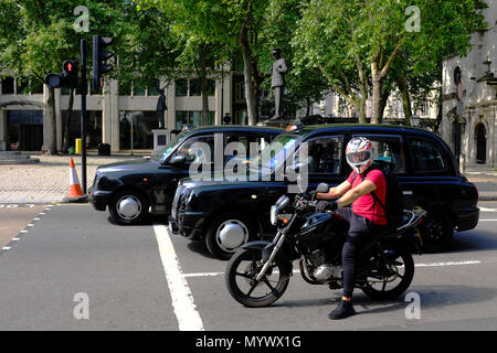 Motorrad und Taxis warten eine Ampel, London, England, Großbritannien Stockfoto