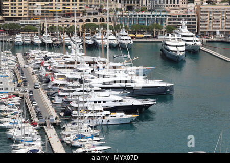 Monte Carlo, Monaco - Juni 7, 2018: Viele Luxuriöse Yachten vor Anker im Hafen Port Hercule, Architektur von Gebäuden und Wolkenkratzern im Hintergrund. Princip Stockfoto