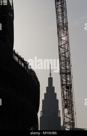 Der unverkennbare NTT Docomo Tower, der hinter dem neuen Nationalstadion zu sehen ist, das zur Vorbereitung der Olympischen Spiele 2020 in Tokio, Gaiemmae, Tokio, Japan, gebaut wird Stockfoto