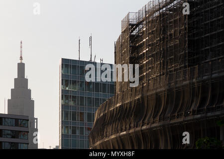 Der unverkennbare NTT Docomo Tower, der hinter dem neuen Nationalstadion zu sehen ist, das zur Vorbereitung der Olympischen Spiele 2020 in Tokio, Gaiemmae, Tokio, Japan, gebaut wird Stockfoto