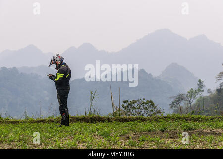 Ein motorradfahrer Prüfen Sie die Karte auf seinem Gerät während der Ha Giang Loop in der Provinz Ha Giang, Vietnam Stockfoto