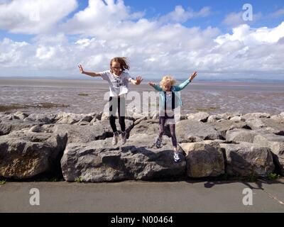 Großbritannien Wetter 29. August 2015. Sonnigen Nachmittag in Morecambe in Lancashire. Zwei junge Mädchen viel Spaß auf der Promenade am Morecambe mit Morecambe Bay hinter. Stockfoto