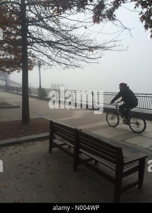 London, UK. 1. November 2015. UK, Wetter. Ein Radfahrer trotzt die Kälte am Morgen und nimmt in der Hauptstadt Nebel entlang der Thames Path in Canary Wharf. Bildnachweis: Glenn Sontag/StockimoNews/Alamy Live-Nachrichten Stockfoto