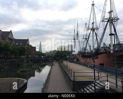 Wapping Ln, London, UK. 28. Mai 2017. London, UK. 28. Mai 2017. Grauen Himmel ist hinter den Shard London gesehen, wie ein Jogger vorbei das Tobacco Dock Piratenschiff in Ost-London bei mild aber feucht Wetter läuft. Bildnachweis: Vickie Flores/StockimoNews/Alamy Live-Nachrichten Stockfoto