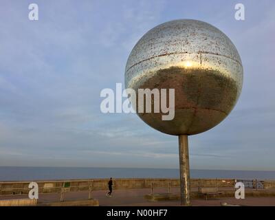 Uk Wetter: diesig Sonne in Blackpool. blauer Himmel und kalten Morgen auf Blackpool South Promenade wie am frühen Morgen Jogger läuft vorbei an der riesigen Glitter ball Skulptur. Stockfoto