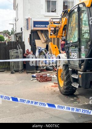 Farnham, Großbritannien. 09 Juli, 2018. Ram Raid bei Tesco Express, Farnham, Surrey, Großbritannien Ridgway Straße, Farnham. 09. Juli 2018. Ein JCB wurde verwendet, um Ram Raid der örtlichen Tesco Express Stores in Farnham. Diebe aus, die mit einer ATM. Credit: jamesjagger/StockimoNews/Alamy leben Nachrichten Stockfoto