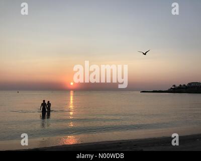 Spanien Wetter, den 5. August 2018 ein Paar am frühen Morgen genießen Schwimmen zu schlagen, um die Wärme, die Sonne an der Costa Blanca als Teile von Spanien und Portugal zu Temperaturen von 40°C erreichen. Stockfoto