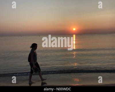 Spanien: Wetter, 05. August 2018 Eine Frau geht auf den Strand an der Costa Blanca bei Sonnenaufgang, die Hitze zu schlagen, als Teile von Spanien und Portugal erreichen Temperaturen von 40 C Stockfoto