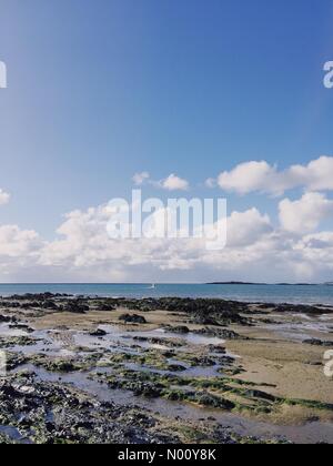 Anglesey, UK. 27. Oktober 2018. Ein einsamer Surfer auf Bootfahren Beach Bay, Rhosneigr, Anglesey, North Wales, UK, auf einem sonnigen aber windigen Herbsttag Ende Oktober Credit: Charlotte Machin/StockimoNews/Alamy leben Nachrichten Stockfoto