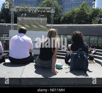 London, Großbritannien. 4. Juli 2019. UK Wetter: Zwei Frauen ihre Mittagspause verbringen Wimbledon auf der Leinwand auf die London Bridge unter azurblauem Himmel. Credit: Paul Swinney/StockimoNews/Alamy Live News Credit: Paul Swinney/StockimoNews/Alamy leben Nachrichten Stockfoto