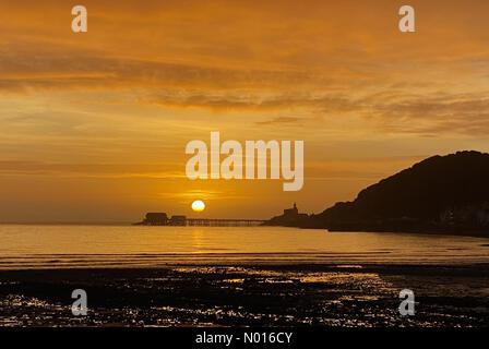 Die Sonne geht über der Rettungsbootstation am Ende des Piers im kleinen Küstendorf Mumbles, Swansea, zu Beginn eines kalten Wintertages auf. Quelle: Phil Rees/StockimoNews/Alamy Live News Stockfoto