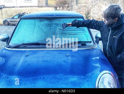 UK Wetter: Jack Porter kratzt Eis von einer gefrorenen Autoscheibe vor der Schule in frostigen Doddiscombsleigh, Devon, Großbritannien. 11th. Februar 2022. Credit nidpor/Alamy Live News Credit: Nidpor/StockimoNews/Alamy Live News Stockfoto