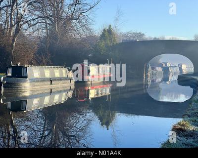 Wetter in Großbritannien: Sonnig und frostig in Adlington. Reflexionen schmaler Boote auf dem Leeds- und Liverpool-Kanal bei Adlington in Lancashire an einem nebeligen Wintermorgen Stockfoto