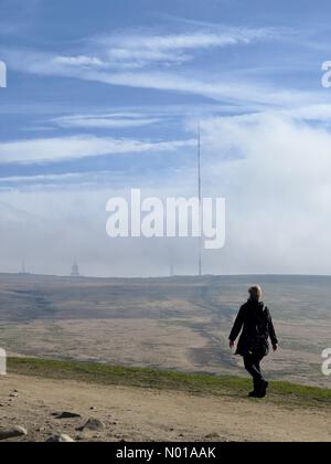 Wetter in Großbritannien: Sonnig in Rivington, Lancashire. Ein sonniger Ostersonntag in Rivington bei Chorley in Lancashire. Ein windiger Morgen auf der Spitze des Rivington Pike mit Frau Walking und Winter Hill TV Mast Stockfoto