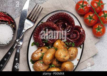 Gegrillter Tintenfisch mit kleinen Kartoffeln mit Kräutern und Gewürzen. Ansicht von oben mit Platz für Ihren Text Stockfoto