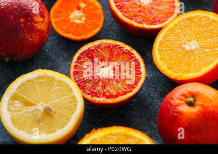 Mischung aus frische reife Zitrusfrüchte wie Orangen, Mandarinen, Zitronen auf einem blauen Stein. Close Up. Stockfoto