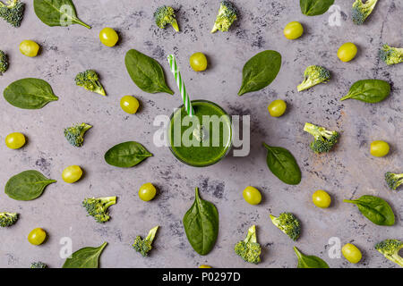 Grüne Smoothie mit Zutaten auf der Betonoberfläche, Ansicht von oben. Stockfoto