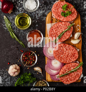 Rohes Hackfleisch Fleisch steak Schnitzel mit Kräutern und Gewürzen auf dsrk Hintergrund. Stockfoto