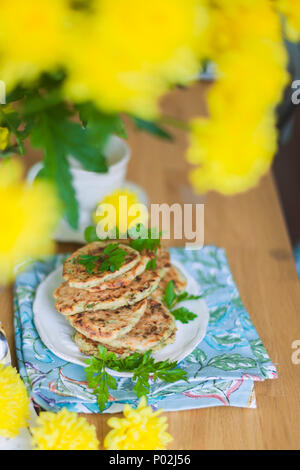 Pfannkuchen aus Gemüse auf den Tisch. Gelbe Blüten. Gesundes Essen. Vegetarisch Stockfoto