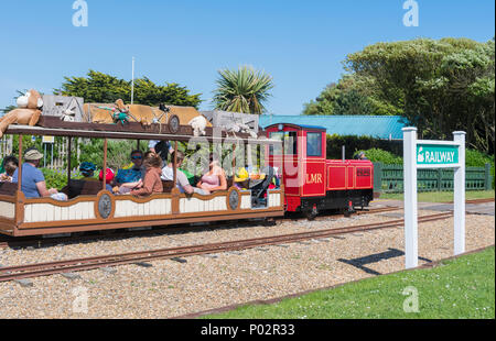 Kleine Lokomotive und Menschen Reiten auf der Littlehampton Miniatur-eisenbahn bei Norfolk Gärten, Littlehampton, West Sussex, England, UK. Stockfoto