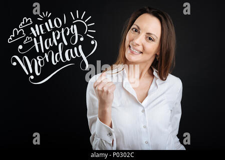 Positive Frau in eine weiße Bluse lächelnd, während ein guter Tag in Stockfoto