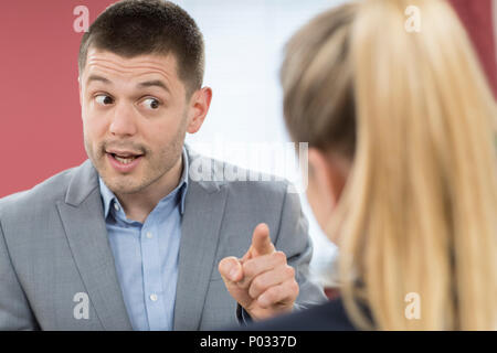 Aggressive Geschäftsmann Mobbing Kollegin im Büro Stockfoto