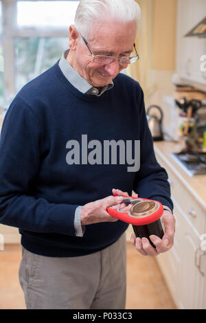 Älterer Mann in der Küche Die Deckel aus Glas mit Kitchen Aid Stockfoto