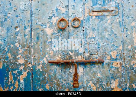 Nahaufnahme von verschlissenen peeling Holztür vibrant Blue mit rostigen Vorhängeschloss und Briefkasten gemalt. Reichlich redaktionellen Raum Stockfoto