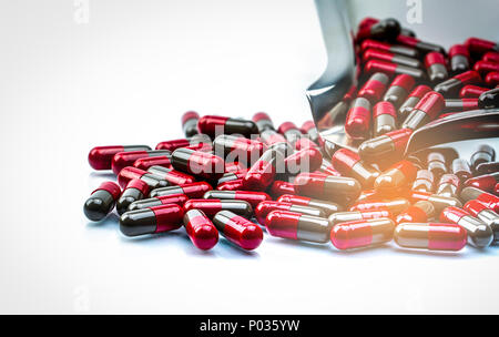 Makroaufnahme detail selektiven Fokus Rot und Grau Kapsel Pillen isoliert auf Edelstahl Droge fach Migräne Prophylaxe Behandlung Konzept. Global Stockfoto