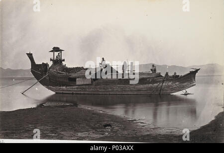 . Foto mit einem Strahl auf eine laung - Zat oder paddy Boot an der Seite des Irrawaddy Fluss festgemacht, von J.Jackson in c 1868, Teil eines Albums von 43 Ansichten von Birma (Myanmar) von sladen Sammlung. Die laung - zat ist eine traditionelle burmesische Fluss Schiff und wurde verwendet, um Reis zu transportieren in Rangun (Yangon). Im 19. Jahrhundert Reis war Burma's wichtigsten landwirtschaftlichen Kulturpflanzen und ihre größte exportieren. Profil des Bootes ist deutlich gezeigt: eine lange, schmale Rumpf, mit einem hohen Stern, und unteren Bogen von unten nach oben gekehrt. Am hinteren Ende der Steuermann sitzt unterhalb ein Tierheim auf einem erhöhten Sitz. A b Stockfoto