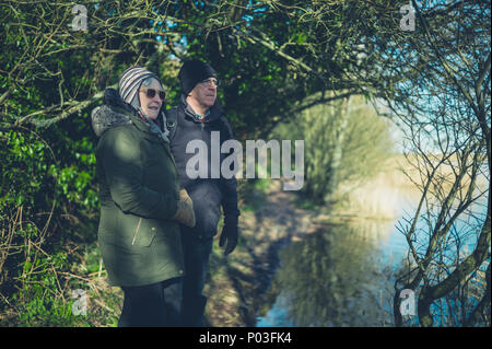 Ein älteres Paar beim Eintritt in den Ruhestand an einem See im Winter Stockfoto