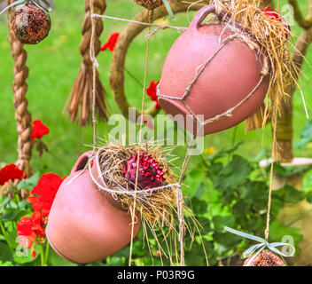 Anordnung der Hängende Blumentöpfe mit grünen Zimmerpflanzen gegen dekorative Gitter. Stockfoto