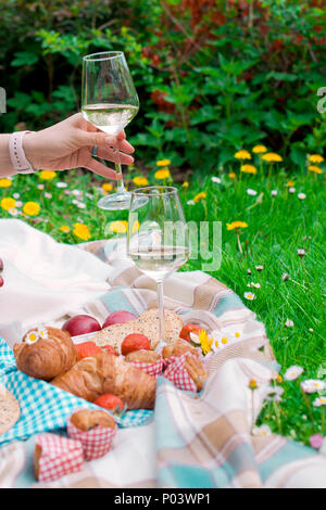 Mädchen an Picknick, auf grünem Gras im Park. Happy Weekend. Wein und Obst. Romantisches Abendessen. Frühling in den Niederlanden. Für Text platzieren. Stockfoto