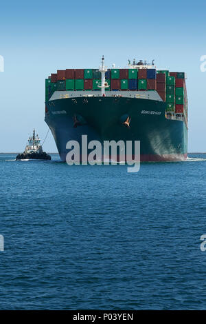 Das Containerschiff, SEAMAX NEW HAVEN, geleitet von Traktor Schlepper, betritt den Los Angeles wichtigste Kanal in den Hafen von Los Angeles, Kalifornien, USA. Stockfoto