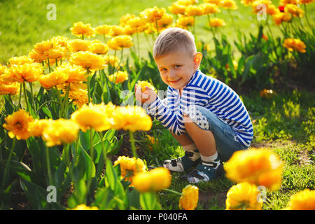 kleiner Junge mit Blumen Stockfoto