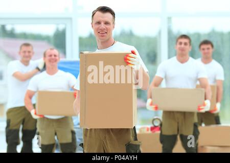 Meister und Arbeiter mit Boxen von Baustoffen Stockfoto