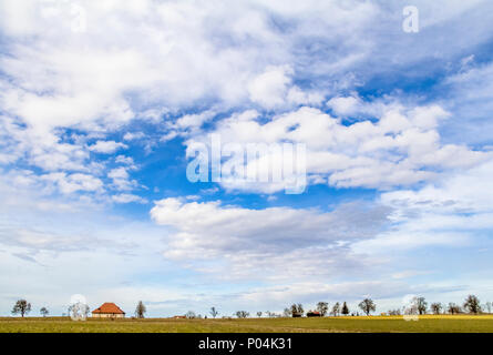 Viele teils bewölkte Himmel und kleine ländliche Landschaft im frühen Frühling in Süddeutschland Stockfoto