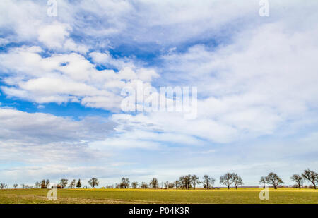 Viele teils bewölkte Himmel und kleine ländliche Landschaft im frühen Frühling in Süddeutschland Stockfoto