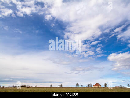 Viele teils bewölkte Himmel und kleine ländliche Landschaft im frühen Frühling in Süddeutschland Stockfoto