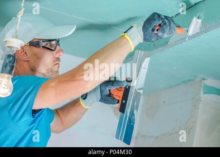 Kaukasische Umgestaltenfremdfirma in den Prozess der Trockenbau patchen. Stockfoto